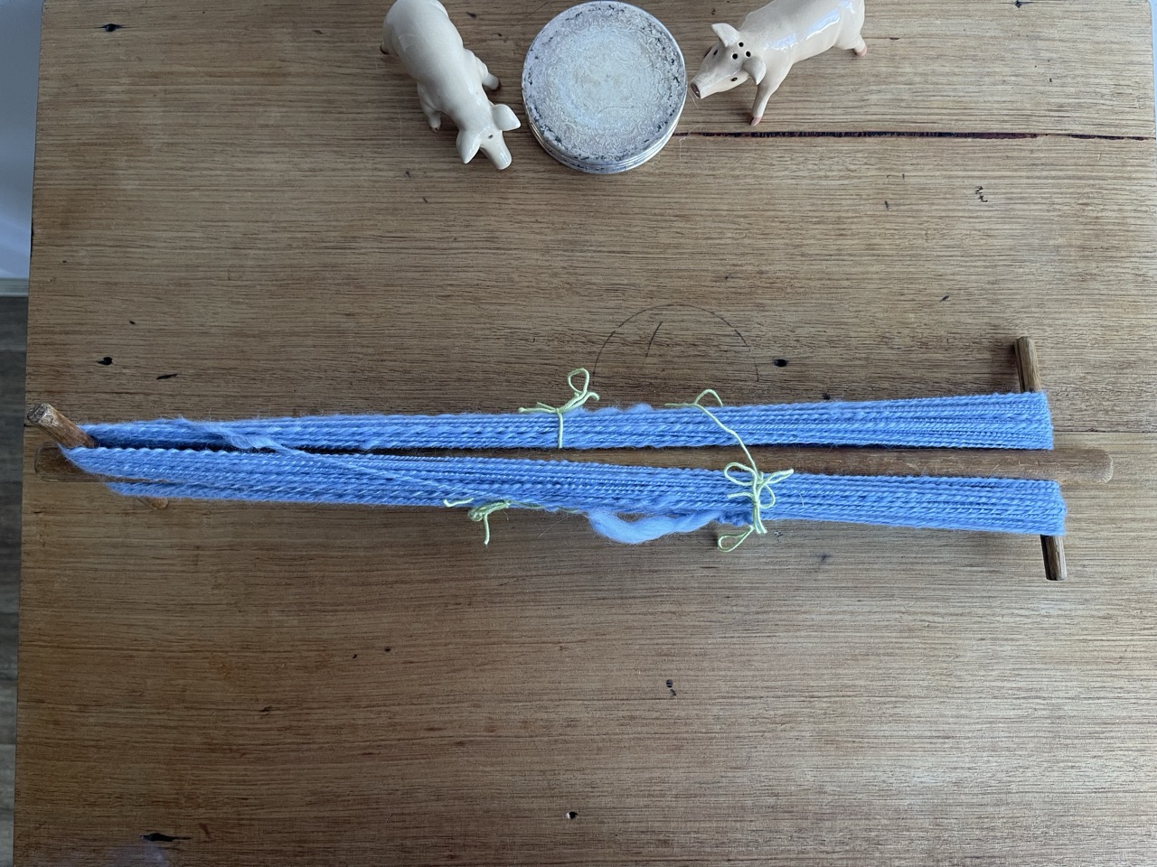 blue merino yarn resting on a niddy noddy